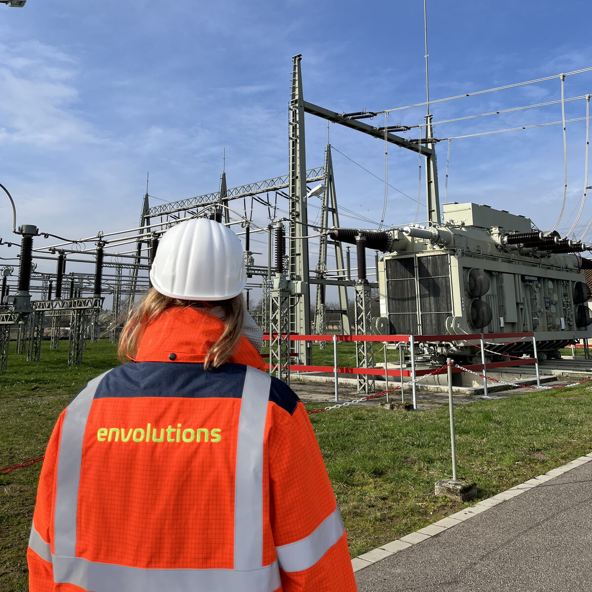 envolutions Mitarbeiter vor einem großen Umspannwerk