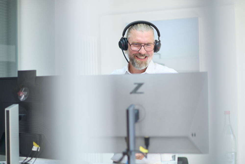 Oliver Paech in seinem Büro mit Headset