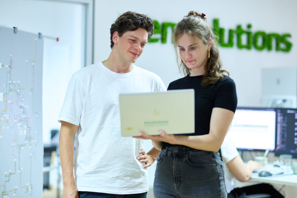 Besprechung von zwei Mitarbeiter an einem Laptop